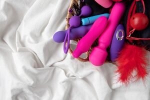 Uma Visão Aproximada De Vários Brinquedos Sexuais Dispostos Sobre Uma Superfície, Incluindo Vibradores E Outros Itens De Melhoria Da Intimidade.