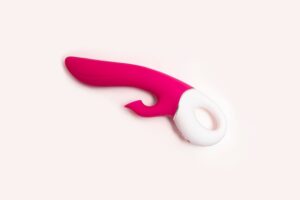 Um Vibrador Rosa Para O Ponto G Com Função De Sucção Clitoriana, Exibido Sobre Um Fundo Branco.