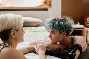 Um Jovem Casal Lésbico Se Olha Nos Olhos Enquanto Relaxa Em Casa, Criando Uma Atmosfera Segura E íNtima Para Explorar Sua Sexualidade.