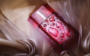 Uma Garrafa De Perfume Rosa Elegante Com Um Design Sofisticado, Em Um Fundo Rosa Suave, Apresentando Conceitos Criativos De Publicidade De Perfumes.