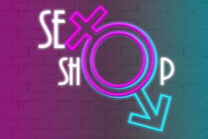 Uma Placa De Neon Brilhantemente Iluminada Exibindo A Inscrição 'Sex Shop' Contra Um Fundo Escuro, Enfatizando A Qualidade Dos Produtos E A Privacidade.