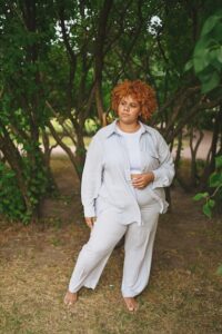 Mulher Afro-americana De Tamanho Grande Vestindo Terno Claro Com Calças.