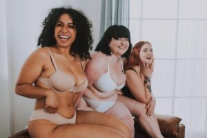 Retrato De Uma Jovem Mulher Vestindo Lingerie, Sentada Em Um Sofá, Dentro De Casa.