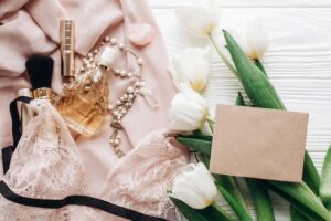Composição Em Plano Superior De Lingerie Rendada, Perfume, Joias, Tulipas E Cartão De Felicitações.
