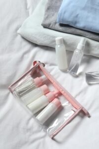 Kit De Viagem De Cosméticos Com Saco Plástico E Pequenos Frascos Sobre A Cama