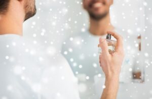 Um Jovem Aplica Perfume Diante Do Espelho.