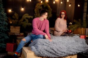 Casal Aconchegante Em Uma Sala De Estar Natalina, Com Iluminação Suave, Cercado De Presentes E Com Uma Lâmpada.