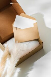 Envelope De Envio Marrom Sobre Fundo Claro, Com Elementos Decorativos.