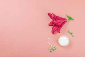 Conceito De Cosméticos Com Um Lírio Vermelho Sobre Um Fundo Rosa Suave.