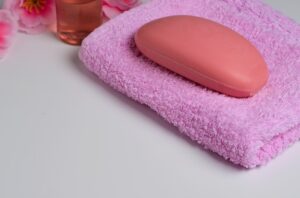 Uma Barra De Sabão Rosa Ao Lado De Uma Toalha Sugere Fórmula Suave Para Pele Sensível.