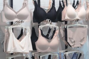 Roupas íNtimas Penduradas Em Cabides, Organizadas Por Cor E Estilo; Sutiãs E Calcinhas Em Exibição.
